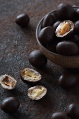 peanuts in chocolate on a dark metal