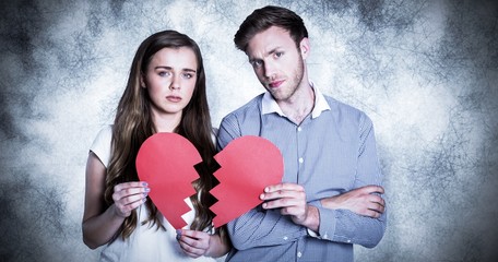 Composite image of couple holding broken heart