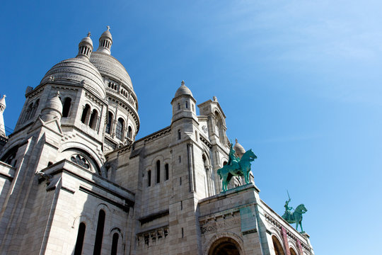 Color DSLR image of Basilica of the Sacre Couer on Montmartre, Paris, France with clear blue sky. Catholic church cathedral is popular Europe tourist destination. Vertical with copy space for text.
