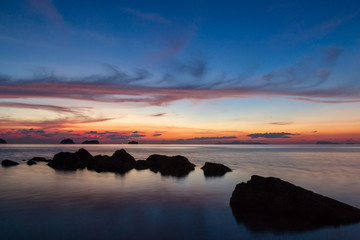 Colored sunset over the  tropical sea, stones and cliffs