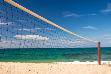 Beach volley net, blue sky and sea in the background