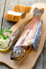 Geräucherte Forelle mit Meerrettich, Zitrone und Baguette rustikal serviert