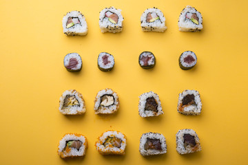 Various kinds of sushi food served on yellow blackground