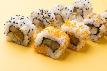 Various kinds of sushi food served on yellow blackground