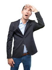 Shocked young businessman looking up