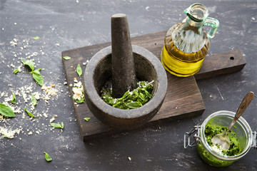Basil pesto in a mortar on a wooden background