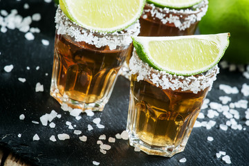 Mexican tequila in a glass, sprinkle with salt with slices of li