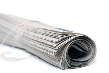 Close view of a rolled up newspaper with string isolated on a white background.