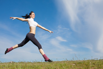 Fototapeta premium Attractive young woman jumping on open air