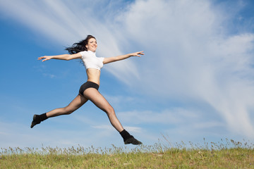 Attractive young woman jumping on open air