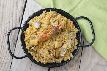 Vegetable paella with seafood on a wooden background