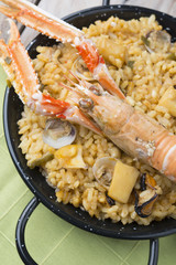 Vegetable paella with seafood on a wooden background