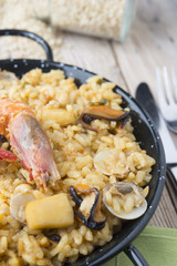 Vegetable paella with seafood on a wooden background