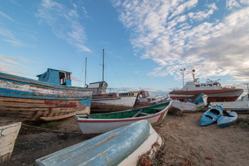 View of many traditional fishing boats anchored on low tide near Santa Luzia village, Portugal.