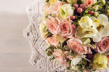 Beautiful wedding bouquet of roses and freesia on white wooden background, background for valentines or wedding day  