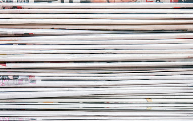 View of a pile of newspapers stacked isolated on a white background.