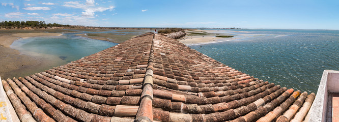 View of traditional rooftops of the Algarve region next to Ria Formosa marshlands, Portugal.