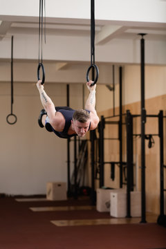 Caucasian athlete hanging on gymnastic rings