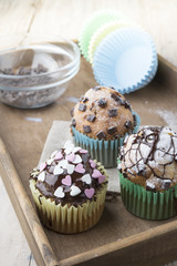 Photo of tasty cupcakes with chocolate over wooden table