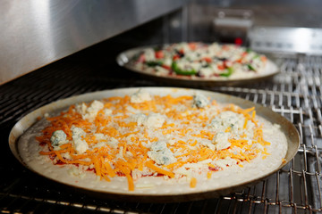 Cheese pizza entering the industrial oven