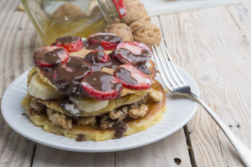 delicious pancakes with nuts, banana, strawberry and chocolate