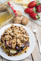 Pancakes with banana , walnut & chocolate on wood background