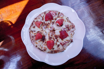 strawberry pizza on white plate.