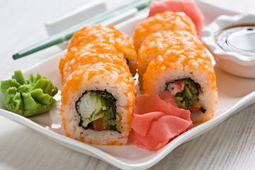 Sushi rolls / Japanese sushi with Masago, wasabi, soy sauce and ginger on white plate