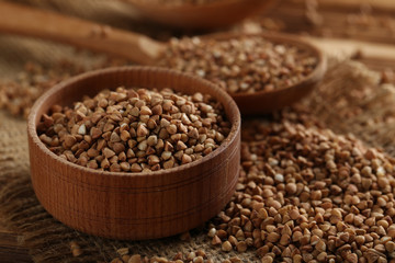 Buckwheat seeds in bowl on a brown wooden table
