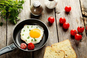 Fried eggs in pan on grey wooden table