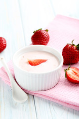 Strawberry yogurt in bowl on a blue wooden table