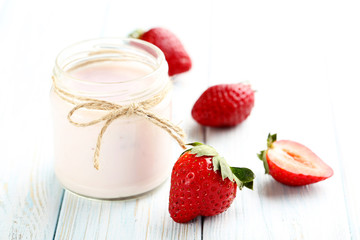Strawberry yogurt in glass on a blue wooden table