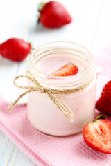 Strawberry yogurt in glass on a blue wooden table