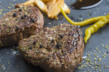 Grilled T-bone steak seasoned with spices and fresh herbs served