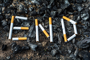 On the ground, scattered coals (ash). On the coals of cigarettes lined inscription 