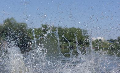 Water spray on the background of trees.