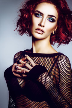 Beautiful gothic girl hipster model with piercings, with red hair, make-up art in black svitshote in the studio