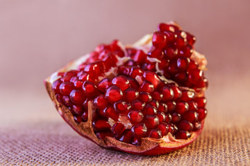 Juicy slice pomegranate on fabric background