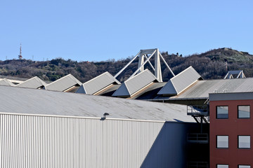 Industrial area on the outskirts with hills on the horizon.