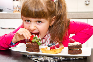 little girl preparing and eating cake with fruit