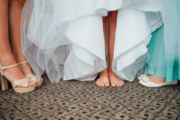 beautiful bride's feet in shoes and white dress