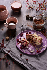 Cake with cranberry and almond, hot cocoa drink and cocoa powder on wooden background.