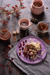 Cocoa drink with cinnamon, cranberry cake, cocoa powder, wooden background, overhead top view.
