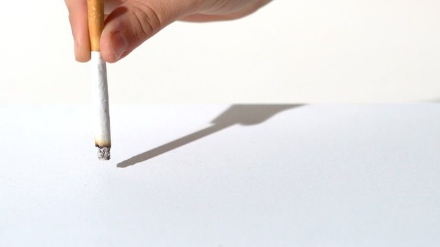 Woman crushing a cigarette on a white table