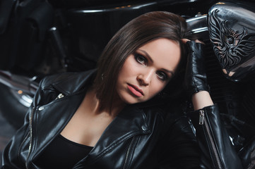Fototapeta na wymiar Portrait of a girl in a leather jacket near a motorcycle