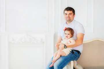 A portrait of a father with sweet fashion baby girl in studio