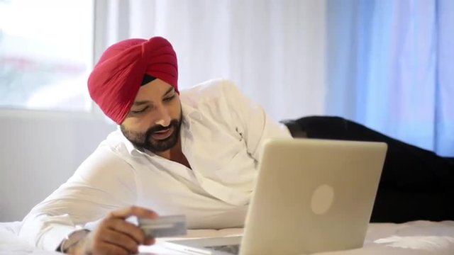 Shot of a Sikh man doing online shopping with a credit card
