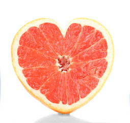 Half of ripe grapefruit in heart shape isolated on white