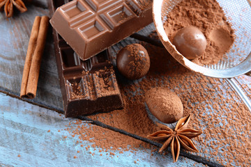 Chocolate sweets with powder on wooden background