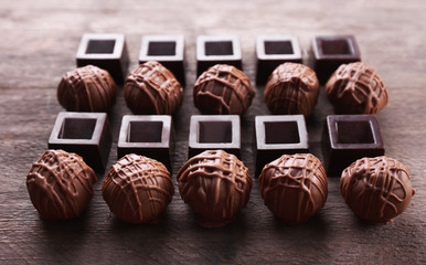 Delicious chocolate candies on wooden background